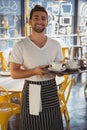 Portrait of waiter holding tray in cafe Royalty Free Stock Photo