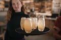 Smiling bar waitress holding a tray of drinks