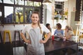 Portrait of smiling young waitress with hands on hip at cafe Royalty Free Stock Photo