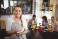 Portrait of smiling young waitress with notepad at cafe Royalty Free Stock Photo