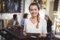 Smiling young waitress with menu at cafe Royalty Free Stock Photo