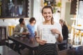 Smiling waitress standing with menu card at cafe Royalty Free Stock Photo