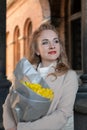 Portrait of smiling young woman with bouquet of yellow flowers outdoors. Date with beautiful girl. Vertical frame Royalty Free Stock Photo