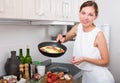 smiling woman making omelet Royalty Free Stock Photo
