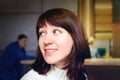 Portrait of smiling young woman with dark hair sitting in a coffee shop Royalty Free Stock Photo