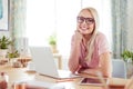 Portrait of smiling young woman at the desk at home