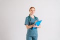 Portrait of smiling young woman doctor in medical uniform writing prescription on clipboard, fills out medical history Royalty Free Stock Photo