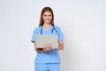 Portrait of smiling young woman doctor with stethoscope holding in hands laptop isolate on white background Royalty Free Stock Photo