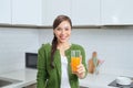 Portrait of a smiling young woman drinking orange juice in the kitchen at home Royalty Free Stock Photo