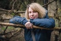 Portrait of a smiling young woman with blonde hair in a coniferous forest in early spring Royalty Free Stock Photo