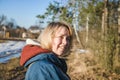 Portrait of a smiling young woman at the edge of the forest in early spring Royalty Free Stock Photo