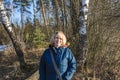 Portrait of a smiling young woman at the edge of the forest in early spring Royalty Free Stock Photo