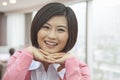 Portrait of Smiling Young Woman with Hands Under Her Chin, Looking At Camera Royalty Free Stock Photo