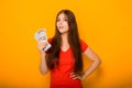 Portrait of a smiling young woman holding a bunch of money banknotes in hands isolated on a yellow background. Royalty Free Stock Photo