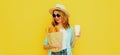 Portrait smiling young woman holding grocery shopping paper bag with long white bread baguette and coffee cup on a yellow Royalty Free Stock Photo