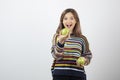 Portrait of a smiling young woman holding two fresh green apples Royalty Free Stock Photo