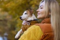 Portrait of a smiling young woman kissing a dog in a field. Dog lover stylish Royalty Free Stock Photo