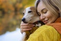 Portrait of a smiling young woman kissing a dog in a field. Dog lover stylish Royalty Free Stock Photo