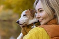 Portrait of a smiling young woman kissing a dog in a field. Dog lover stylish Royalty Free Stock Photo