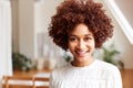 Portrait Of Smiling Young Woman In Loft Apartment