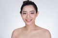 Portrait of a smiling young woman with natural make-up. beautiful asian girl standing against white background. Royalty Free Stock Photo