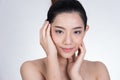 Portrait of a smiling young woman with natural make-up. beautiful asian girl standing against white background. Royalty Free Stock Photo