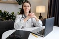 Portrait of smiling young woman nurse sitting at desk in hospital or private clinic. Happy positive caucasian female doctor in Royalty Free Stock Photo