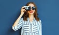 Portrait smiling young woman photographer with vintage film camera over blue wall Royalty Free Stock Photo