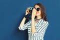 Portrait smiling young woman photographer with vintage film camera over blue wall Royalty Free Stock Photo