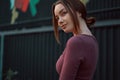 Portrait of smiling young woman posing against dark wall Royalty Free Stock Photo