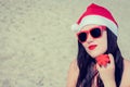 Portrait of a smiling young woman in Santa Claus hat and sungla Royalty Free Stock Photo