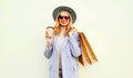 Portrait smiling young woman with shopping bags, holding coffee cup, wearing pink coat, round hat Royalty Free Stock Photo