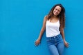 Portrait of smiling young woman standing against blue wall Royalty Free Stock Photo