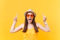 Portrait of smiling young woman in straw summer hat, orange glasses pointing index fingers up on copy space isolated on Royalty Free Stock Photo