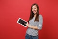 Portrait of smiling young woman in striped clothes holding tablet pc computer with blank black empty screen isolated on Royalty Free Stock Photo