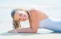 Portrait of smiling young woman in swimsuit laying on sea shore Royalty Free Stock Photo