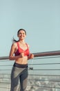 Portrait of smiling athlete running on the bridge at daytime