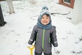 Portrait of smilling little toddler boy in warm clothes, playing outdoors with snow on a winter. Royalty Free Stock Photo