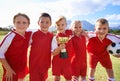 Portrait, soccer team and children with cup, boys and girls with victory, support or proud. Achievement, sports and Royalty Free Stock Photo