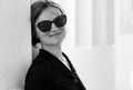 Portrait in soft tones of a beautiful thirty year old cute woman with a black dress and sunglasses