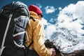 Portrait of solo hiker with traveling backpack standing in front of massive snowy mountains. Tourist among himalayas mountain