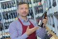 Portrait sommelier with wine bottle in wine shop Royalty Free Stock Photo