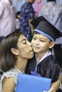 Portrait son graduated from kindergarten and mother kissing