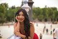 Portrait of South American woman, young, pretty, brunette, wearing an elegant red dress, leaning on a railing looking happy and Royalty Free Stock Photo