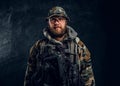 Portrait of a special forces soldier in the military camouflaged uniform, looking at a camera.