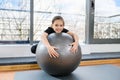 Tween girl with grey sport rubber fitball