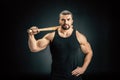 portrait of sportive man standing akimbo with baseball bat on shoulder Royalty Free Stock Photo