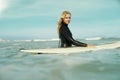 Portrait, sports and woman in ocean with surfboard for sports, travel or vacation in summer. Sky, fitness and exercise