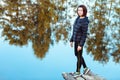 Portrait of sporty beautiful adult brunette woman the fall city park posing near blue lake with autumn trees reflections. Royalty Free Stock Photo