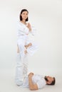 Portrait of sporty family training on white background. Man lying on floor holding with raised legs woman in lotus pose. Royalty Free Stock Photo